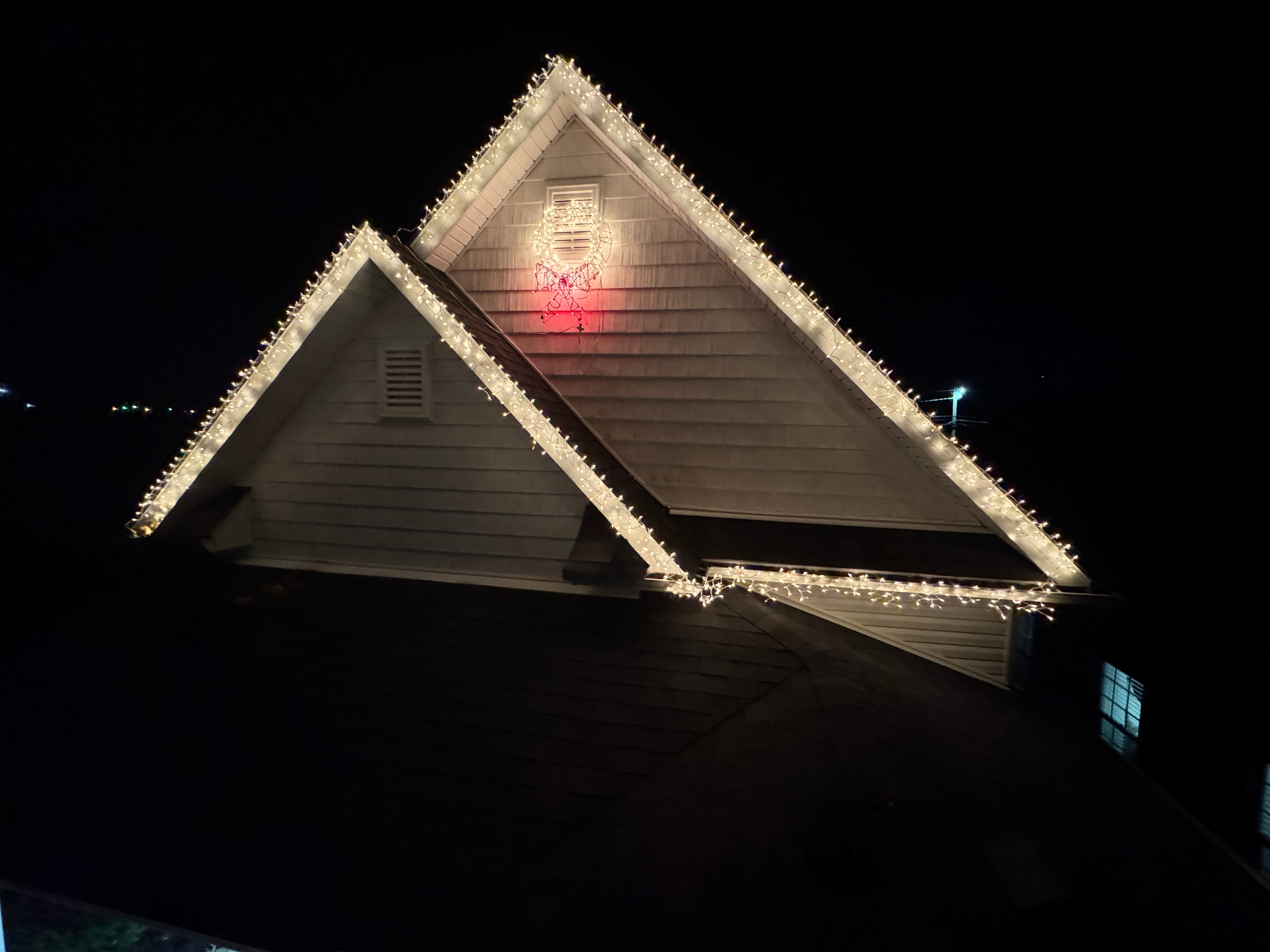 Sudberry home warm white roofline with lit wreath