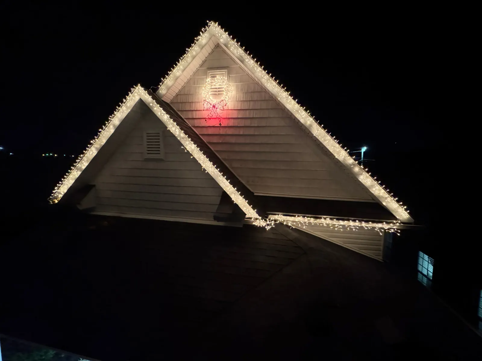 Sudberry home warm white roofline with lit wreath